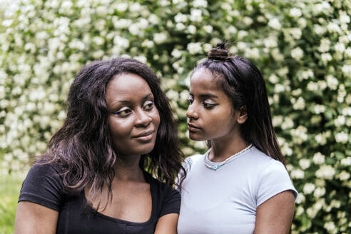 Woman looking at friend contemplating in park - PBTF00037