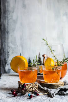 Becher mit Aperitif, Orangensaft und Limette auf dem Tisch - SBDF04650