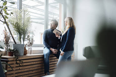 Businesswoman discussing with businessman in office - JOSEF19877