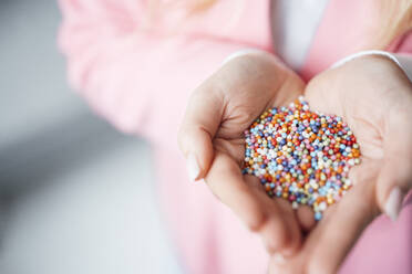 Hands of businesswoman holding multi colored pearl beads - JOSEF19884