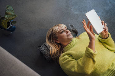 Frau liegt auf dem Boden und benutzt einen Tablet-PC zu Hause - JOSEF19953