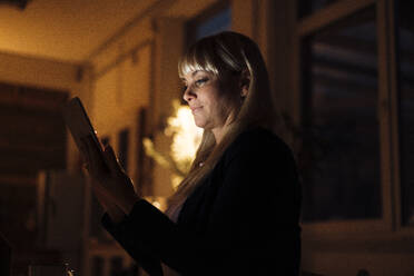 Blonde Frau benutzt Tablet-PC zu Hause in der Nacht - JOSEF19971