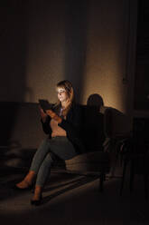 Frau benutzt Tablet-PC auf dem Sofa zu Hause - JOSEF19975