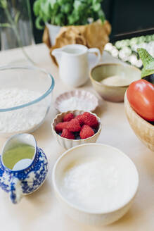 Bowl of berries with ingredients on table - MEUF09132