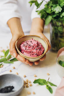 Chefkoch mit Schüssel frischem Rote-Bete-Hummus - MEUF09152