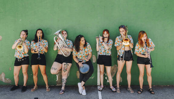 Women's folk music group standing in front of wall - MRRF02653