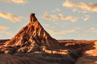 Picturesque view of rough stony formation with uneven surface and dry ground under blue sky in Bardenas Reales desert - ADSF44799