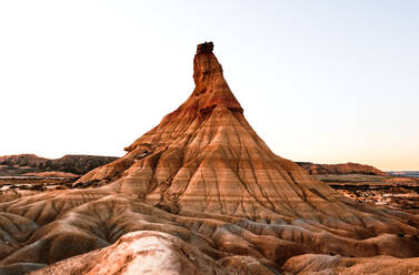 Picturesque view of rough stony formation with uneven surface and dry ground under sky in Bardenas Reales desert - ADSF44800