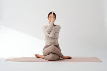 Flexible female yoga instructor with eyes closed exercising at health club  stock photo