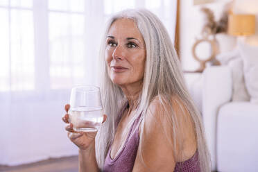 Reife Frau mit einem Glas Wasser zu Hause - OIPF03213