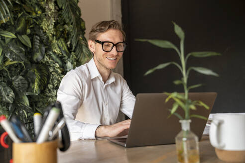 Happy mature businessman working on laptop - VPIF08263