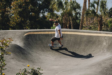 Man practicing stunt on skateboard at park - MRRF02680