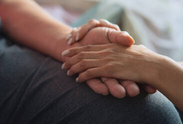 Daughter emotionally supporting and comforting her senior father while holding his hand - ADSF45003