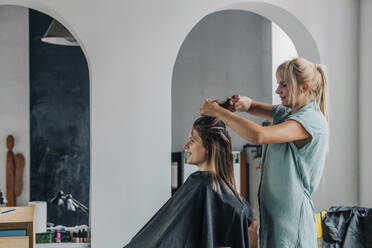 Friseurin beim Färben der Haare eines Kunden im Salon - VSNF01160