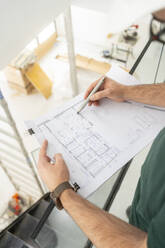 Hands of architect working on blueprint at contsruction site - MMPF00795