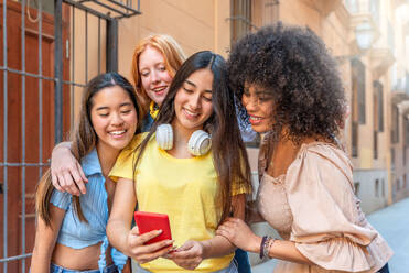 Multicultural group of girlfriends happily taking a selfie in front of Valencia's stunning architecture. - ADSF45129