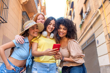 Multicultural group of female friends smiling and taking a selfie in front of Valencia's stunning architecture. - ADSF45132