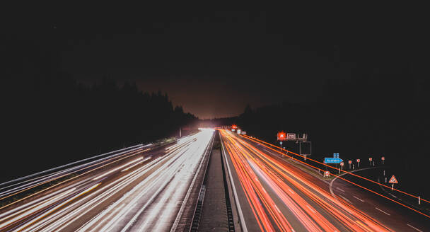 Long exposure shot of bright traces of car lights on busy road at night - ADSF45167
