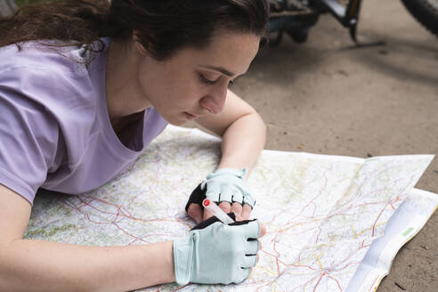 Young woman reading map on road - AMWF01511