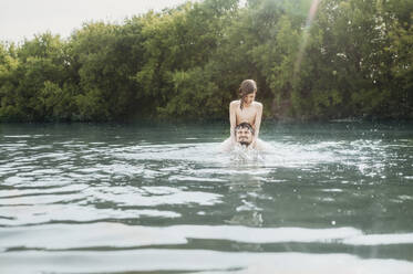 Glücklicher Junge hat Spaß mit Vater im Fluss - ANAF01753