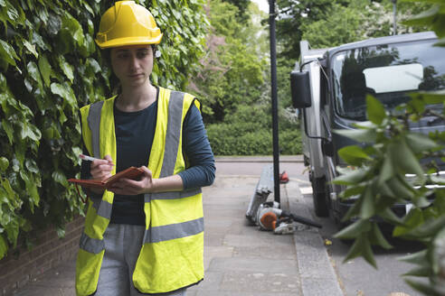 Arbeiter mit Schutzhelm bei der Untersuchung eines umgestürzten Baumes - AMWF01524