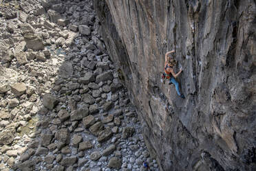 Entschlossene Frau klettert mit Seil auf einen Berg - ALRF02095