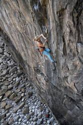 Mature athlete climbing rocky mountain in Pembrokeshire - ALRF02096