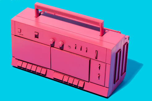 From above of bright pink retro cassette tape recorder placed in studio against blue background - ADSF45202