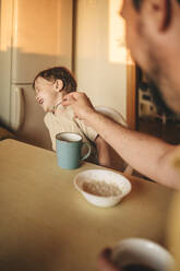 Boy refusing to eat porridge at dining table - ANAF01774