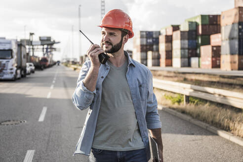 Logistics manager talking on walkie-talkie - UUF29526