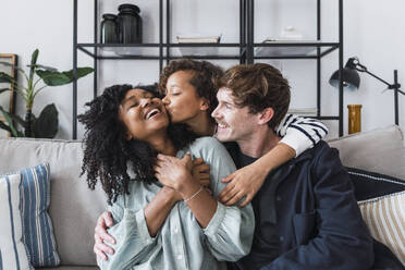 Happy family sitting on couch having fun at home - PNAF05614