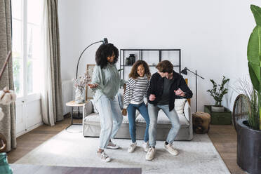 Happy family havin fun dancing together in the living room - PNAF05619