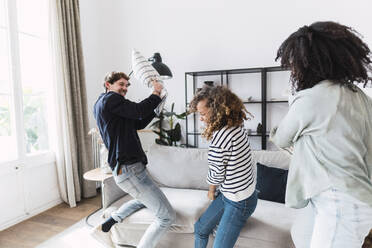 Lively family having fun with a pillow fight at home - PNAF05650