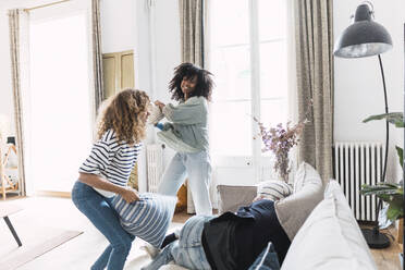 Lively family having fun with a pillow fight at home - PNAF05656