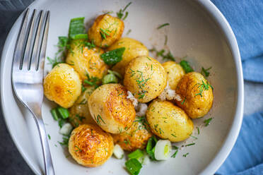 From above fried spring potato vegetables with herbs served in the bowl for lunch - ADSF45459