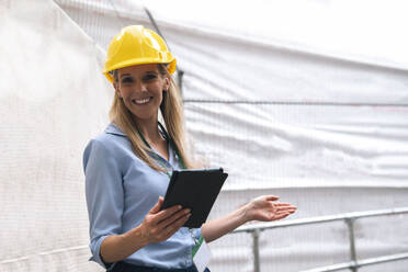 Smiling engineer gesturing holding tablet PC - AMWF01582