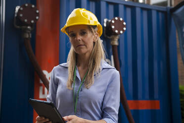 Engineer wearing hardhat holding tablet PC - AMWF01583