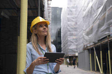 Contemplative engineer holding tablet PC - AMWF01619