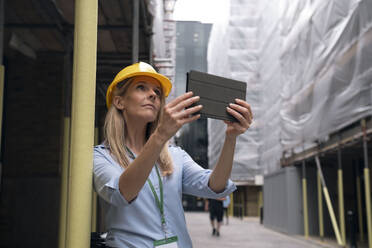 Ingenieur bei der Arbeit mit einem Tablet-PC auf der Baustelle - AMWF01620