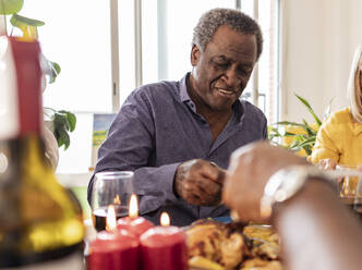 Älterer Mann beim Abendessen mit Freunden zu Hause - JCCMF10625