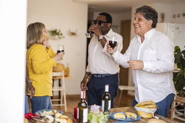 Glücklicher Mann, der sich mit Freunden bei einer Dinnerparty zu Hause amüsiert - JCCMF10644