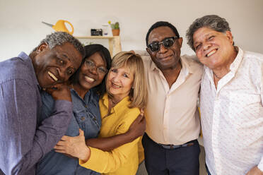 Fröhliche multikulturelle Seniorenfreunde, die sich zu Hause in den Armen liegen - JCCMF10647