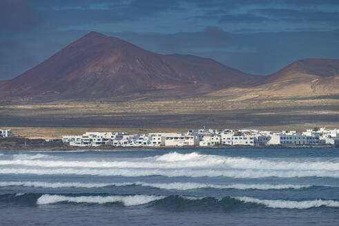 Spanien, Kanarische Inseln, Caleta de Famara, Küstendorf mit Berg im Hintergrund - WGF01467