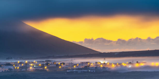 Spain, Canary Islands, Fog-shrouded village on Lanzarote island - WGF01470