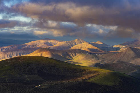 Spain, Canary Islands, La Geria, Clouds over Los Ajaches formation at cloudy dawn - WGF01481