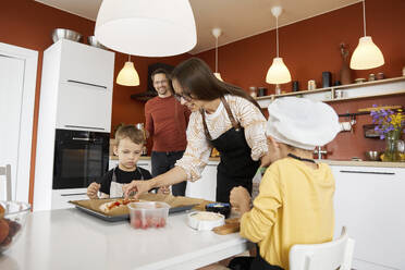 Mutter mit Söhnen bei der Zubereitung einer Pizza zu Hause - SANF00125