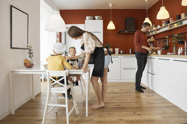 Familie bei der gemeinsamen Zubereitung von Speisen in der Küche zu Hause - SANF00134