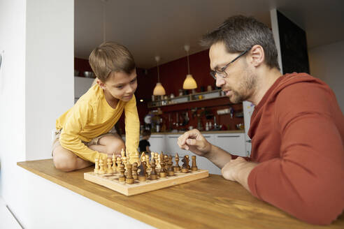 Father and son playing chess at home - SANF00147