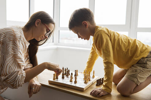 Mutter spielt Schach mit Sohn zu Hause - SANF00154