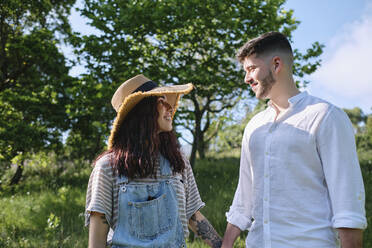 Romantic couple holding hands at park - ASGF03888